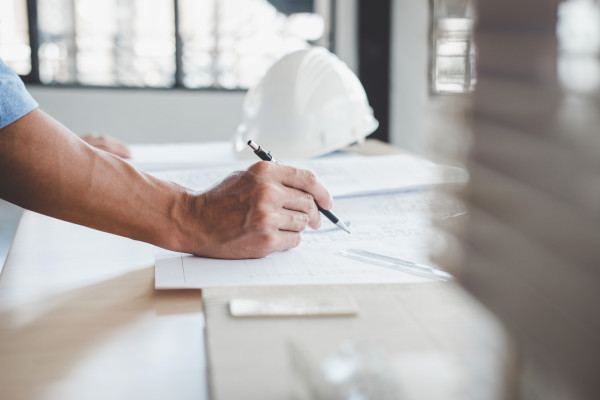 A man drawing on a floor plan