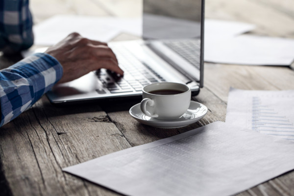 A man using a laptop with coffee